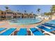 Community pool surrounded by lounge chairs and palm trees, perfect for relaxing at 19417 Gulf Blvd # E217, Indian Shores, FL 33785