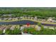 Aerial view of a residential area featuring homes near a pond and surrounded by lush greenery at 19505 Morden Blush Dr, Lutz, FL 33558