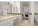 Bathroom featuring dual sinks, mirrors, and decorative tile, leading to a bedroom at 19505 Morden Blush Dr, Lutz, FL 33558