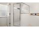 Bathroom with a glass-enclosed shower stall and a small window providing natural light at 19505 Morden Blush Dr, Lutz, FL 33558