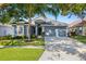Charming single-story home featuring a well-manicured lawn, mature trees, and a two-car garage at 19505 Morden Blush Dr, Lutz, FL 33558