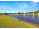 Picturesque lake view with well-maintained lawns and beautiful homes in the background at 19505 Morden Blush Dr, Lutz, FL 33558