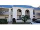 Charming condo building featuring a distinctive blue roof and well-maintained landscaping at 1975 W Bay Dr # 207, Largo, FL 33770