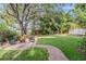 Spacious backyard featuring a brick patio, seating area, and mature trees at 207 Chippewa Ave, Tampa, FL 33606