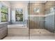 Bathroom featuring a tub, glass shower, and a large window with natural light at 207 Chippewa Ave, Tampa, FL 33606