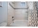 Bathroom features a tub with tile surround, shower head, and a window at 207 Chippewa Ave, Tampa, FL 33606