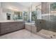 Bathroom featuring double vanities, a soaking tub, and a separate glass shower at 207 Chippewa Ave, Tampa, FL 33606