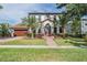Stunning two-story home with a tile roof, lush landscaping, and a brick walkway leading to the front door at 207 Chippewa Ave, Tampa, FL 33606