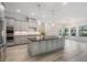 Bright, open kitchen with large island, seating, stainless appliances, and wood-look flooring at 207 Chippewa Ave, Tampa, FL 33606