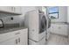 Bright laundry room with white cabinets, granite countertops, stainless washer & dryer at 207 Chippewa Ave, Tampa, FL 33606