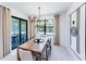 Dining room featuring a modern chandelier, a wooden table and view of the outdoor patio through the sliding glass door at 2535 Charter Oak Dr, North Port, FL 34289