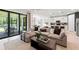 Spacious living room with a comfortable sofa, view of the dining room, kitchen and patio through the sliding glass door at 2535 Charter Oak Dr, North Port, FL 34289