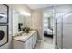 Elegant bathroom featuring double sinks, white cabinets, and a glass-enclosed shower adjacent to the main bedroom at 2535 Charter Oak Dr, North Port, FL 34289
