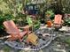 Secluded backyard seating area with an array of chairs surrounded by mature foliage and brick pavers at 2810 Norwood Ln, Venice, FL 34292