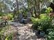 Inviting backyard garden featuring an elegant stone path and patio seating area amidst lush plants at 2810 Norwood Ln, Venice, FL 34292
