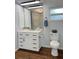 Bathroom featuring a white vanity, toilet, and a mirror with modern lighting fixtures, and a window at 2810 Norwood Ln, Venice, FL 34292