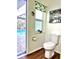 Bright bathroom with a toilet, small frosted window, and a view of the pool through the open doorway at 2810 Norwood Ln, Venice, FL 34292