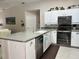 Well-lit kitchen features white cabinets, stainless appliances, and ample counter space at 2810 Norwood Ln, Venice, FL 34292