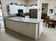 Modern kitchen with white cabinets, stainless steel appliances, and a spacious countertop island at 2810 Norwood Ln, Venice, FL 34292