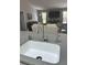 Modern kitchen sink with stone backsplash and a view of living area at 2810 Norwood Ln, Venice, FL 34292