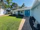 Charming home featuring a well-kept lawn, landscaping, and inviting blue double door entrance at 2860 58Th S Cir, St Petersburg, FL 33712