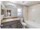 Bathroom featuring a gray vanity with double mirrors, a combination tub and shower, and a view into the hallway at 3208 E 8Th Ave, Tampa, FL 33605