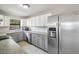 Well-lit kitchen featuring stainless steel refrigerator, gray cabinets, and stone countertops at 3208 E 8Th Ave, Tampa, FL 33605