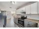 Modern kitchen with stainless steel appliances, granite countertops, and white and gray cabinetry at 3208 E 8Th Ave, Tampa, FL 33605