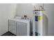 Laundry area featuring a washing machine, dryer, and hot water heater at 3208 E 8Th Ave, Tampa, FL 33605