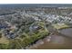Beautiful aerial view of waterfront property with mature trees, dock, and charming coastal-style home at 3484 Shore Dr, Safety Harbor, FL 34695