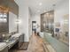 Modern bathroom featuring double vanity, soaking tub, and glass shower with unique tile and wood-look flooring at 3484 Shore Dr, Safety Harbor, FL 34695