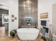 Luxurious bathroom showcasing a soaking tub with decorative tile wall and niche, next to open door to walk-in closet at 3484 Shore Dr, Safety Harbor, FL 34695