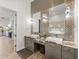 Stylish bathroom with double vanity, granite countertop, decorative lighting, and wood-look floors, and door to walk-in closet at 3484 Shore Dr, Safety Harbor, FL 34695
