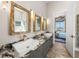 Modern bathroom featuring dual sinks with granite counters, wood look flooring, and views of the water at 3484 Shore Dr, Safety Harbor, FL 34695