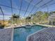 Screened-in pool and jacuzzi surrounded by a brick patio and tropical landscaping at 3484 Shore Dr, Safety Harbor, FL 34695