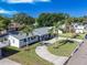 A beautifully landscaped front yard highlights this single-story home with a curved driveway and mature palm trees at 352 79Th Ne Ave, St Petersburg, FL 33702
