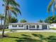Charming single-story home with a well-manicured lawn and beautiful landscaping featuring mature palm trees at 352 79Th Ne Ave, St Petersburg, FL 33702