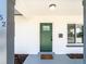 Welcoming front entrance featuring a modern green door, updated lighting fixture, and a stylish welcome mat at 352 79Th Ne Ave, St Petersburg, FL 33702