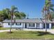 Charming single-story home with an attached garage, complemented by a green lawn and two mature palm trees at 352 79Th Ne Ave, St Petersburg, FL 33702