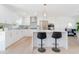 Modern kitchen with white cabinets, a stainless-steel refrigerator, and barstool seating at the island at 352 79Th Ne Ave, St Petersburg, FL 33702