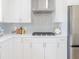 A kitchen featuring white cabinets, light backsplash, and stainless-steel gas range at 352 79Th Ne Ave, St Petersburg, FL 33702