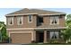 Two story home featuring a two car garage, and a neutral stucco exterior with white trim at 35670 Lockman Way, Zephyrhills, FL 33541
