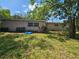 Backyard featuring an open green space, a ladder and a blue kiddie pool at 3714 E Ellicott St, Tampa, FL 33610