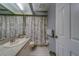Bathroom features a vanity with sink, toilet, tiled floors and patterned shower curtain at 39650 Us Highway 19 N # 743, Tarpon Springs, FL 34689