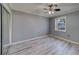 Bright bedroom with wood-look floors, large window and a ceiling fan at 39650 Us Highway 19 N # 743, Tarpon Springs, FL 34689