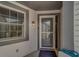 Covered entryway with storm door, modern lighting fixture, and neutral siding at 39650 Us Highway 19 N # 743, Tarpon Springs, FL 34689