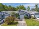 Charming single-story home with a well-manicured lawn, blossoming bushes, and attached one car garage at 39650 Us Highway 19 N # 743, Tarpon Springs, FL 34689