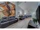 Comfortable living room with black leather couches, tall wall decor and ceiling fan at 39650 Us Highway 19 N # 743, Tarpon Springs, FL 34689