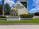 Community entrance sign featuring 'The Woods Deed Restricted' set amidst manicured landscaping at 39650 Us Highway 19 N # 743, Tarpon Springs, FL 34689