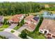 Aerial view of home with tile roof, landscaping, a pond, and situated among other houses at 4024 Woods Rider Loop, Odessa, FL 33556